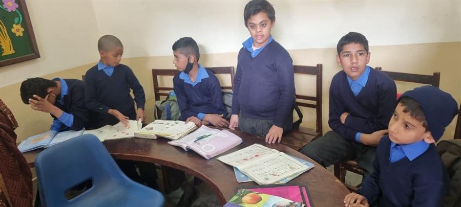 Students sitting at a curved desk with open books