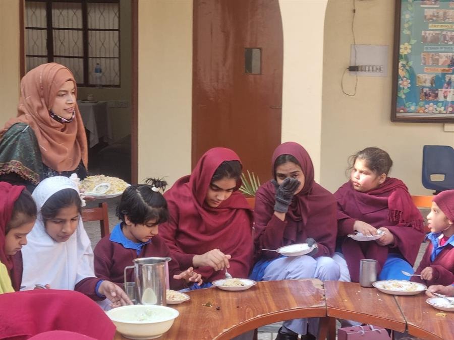 Students eating together around a curved wooden table