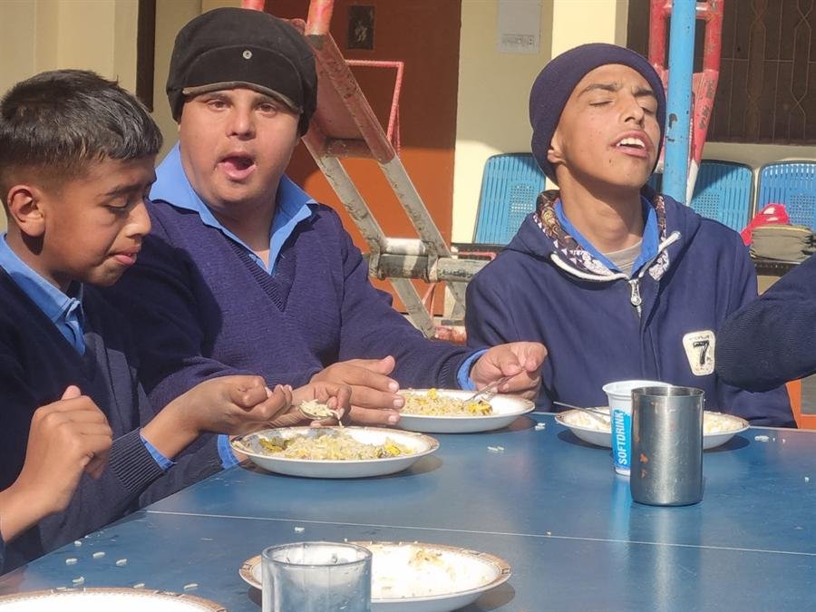 Three students eating rice together at a table