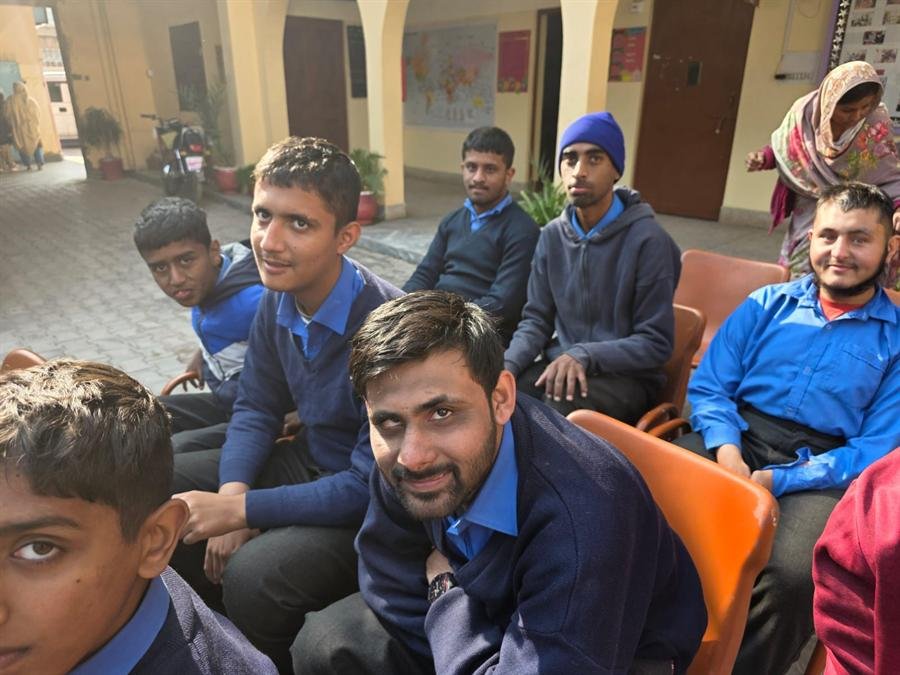 Students and a teacher smiling together at an outdoor event